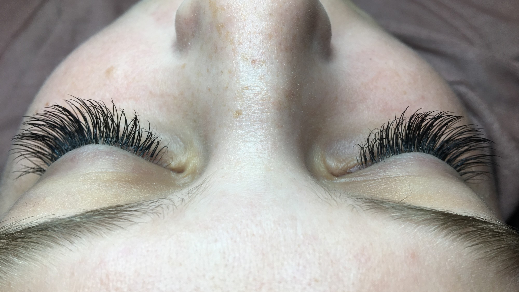 Lash extension work on a client lying back