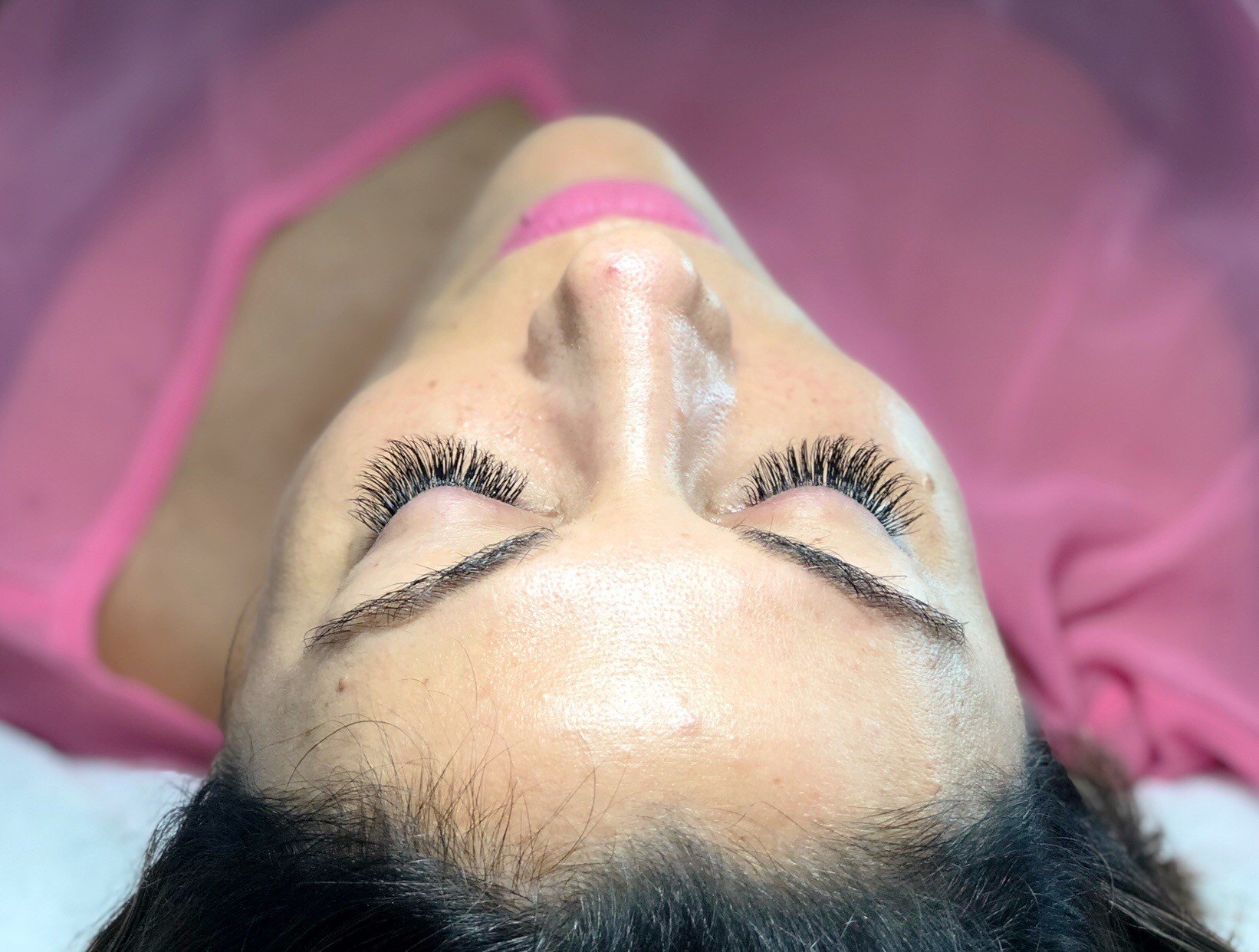 Lash and brow result on a client in a pink robe